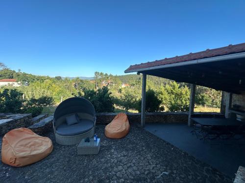 a patio with a couch and pillows on the ground at Casa da Ribeira - Arouca in Lázaro