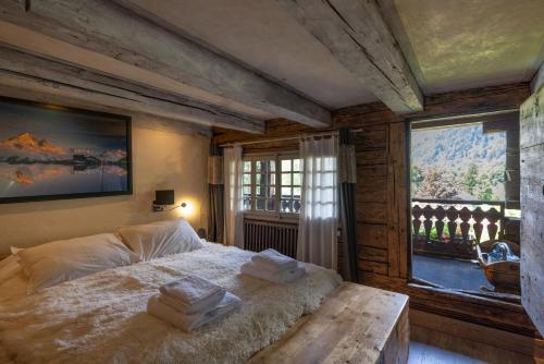 een slaapkamer met een bed en een groot raam bij Chalet authentique luxe piscine in Les Contamines-Montjoie