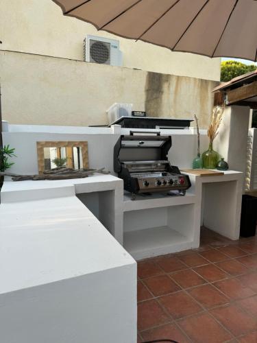 - une table extérieure avec un parasol sur la terrasse dans l'établissement Maison au cœur de la capte, à Hyères