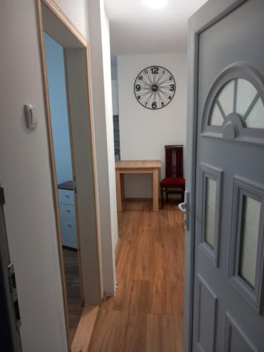 an open door to a hallway with a clock on the wall at rm castell apartments in Novi Sad