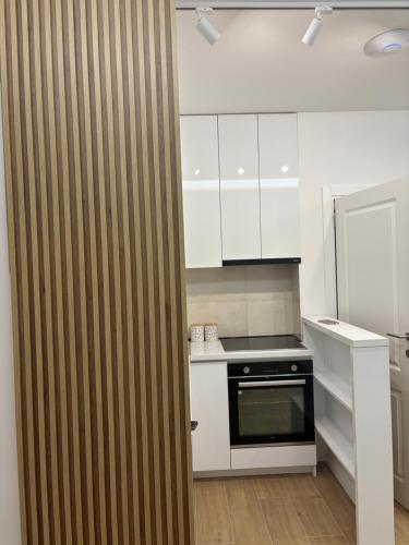 a kitchen with white cabinets and a black oven at Apartmani Milos - Meljine in Herceg-Novi