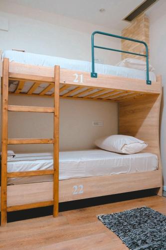 two bunk beds in a room with a rug at Scodrinon Hostel in Shkodër