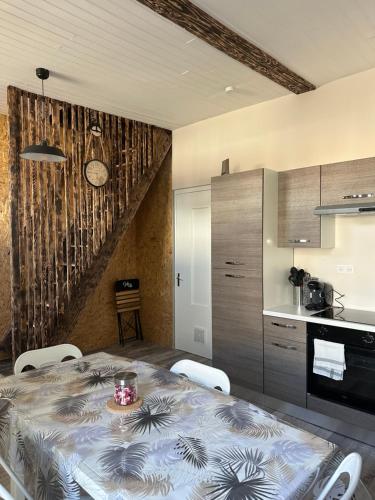 une cuisine avec une table à manger et une cuisine avec un escalier dans l'établissement Maison EZA, à Saint-Yrieix-sur-Charente