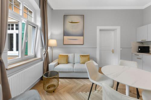 a living room with a white couch and a table at Residenz Hugo in Bad Schandau
