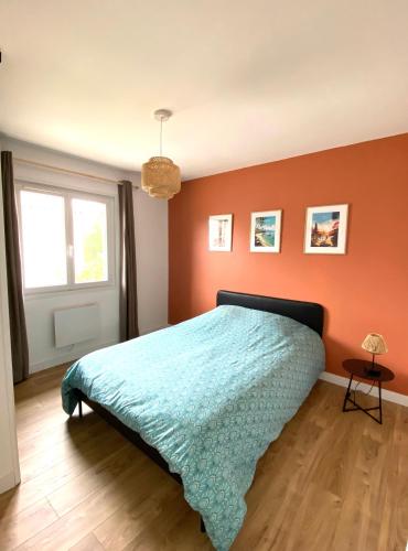 une chambre avec un lit avec un mur orange dans l'établissement Maison 100 m2 avec 3 chambres, à Saint-Caprais-de-Bordeaux