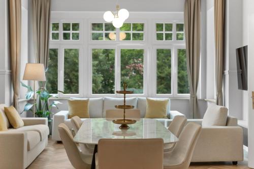 a living room with a table and white furniture at Residenz Hugo in Bad Schandau
