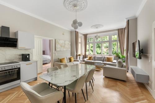 a kitchen and living room with a glass table and chairs at Residenz Hugo in Bad Schandau