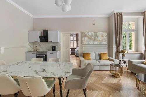 a white living room with a marble table and chairs at Residenz Hugo in Bad Schandau