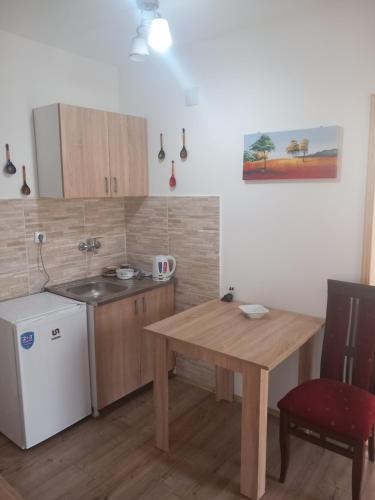 a kitchen with a wooden table and a table and a table and a chair at rm castell apartments in Novi Sad