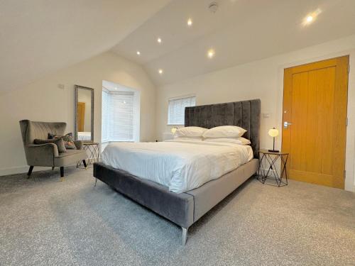 a bedroom with a large bed and a chair at Eagles Cottage, 3 - Bed, Sleeps 6, Pets Welcome - Ulverston in Ulverston