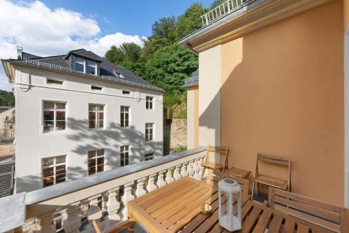 a balcony with a wooden bench and a white building at Residenz Hugo in Bad Schandau