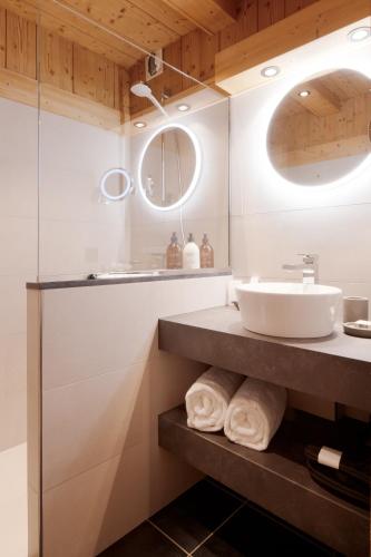 a bathroom with a sink and a mirror at La Ferme du Golf in Megève
