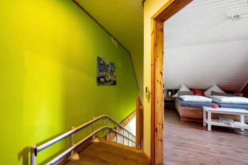 a green room with a staircase and a bed at Inge Huus in Hude