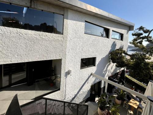 a white building with a balcony with plants at AFTER Hotel in Bastiagueiro
