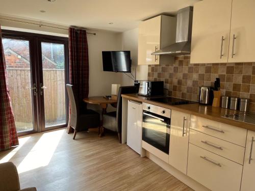 a kitchen with a table and a counter top at Clock Tower Cottage in Nailsworth