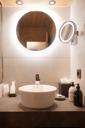 a bathroom with a large white sink and a mirror at La Ferme du Golf in Megève