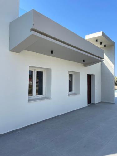 a white house with a large driveway at Pervolia Oasis Villa in Kiti