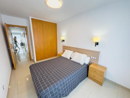 een slaapkamer met een bed en een houten deur bij Apartamento Marina Roses 2 in Roses