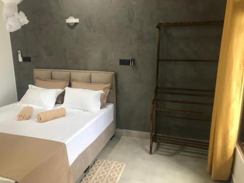 a bedroom with a bed with white pillows and a ladder at Flip Flop Inn Mirissa in Mirissa