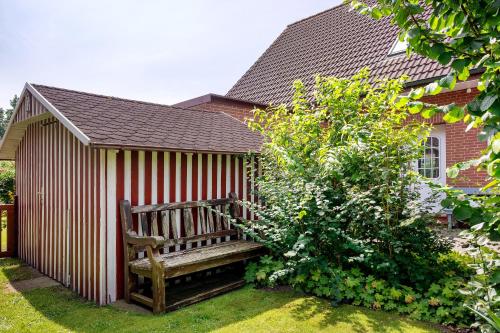 a wooden bench in the backyard of a house at Inge Huus in Hude