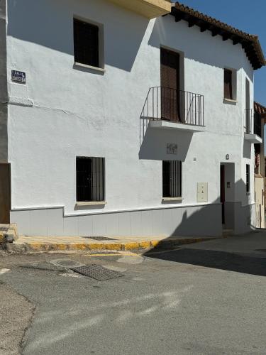 a white building with a staircase on the side of it at Apartamentos Peñaflor in Guadix