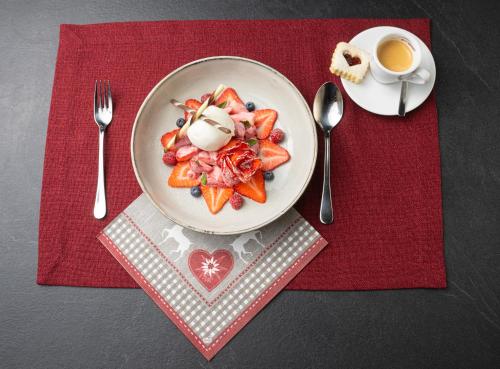 a plate of food on a table with a cup of coffee at Berglodge Ristis in Engelberg