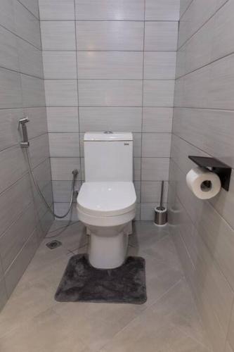 a bathroom with a white toilet in a stall at Serenita Homes Arusha in Arusha