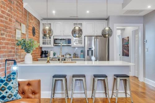 una cucina con bancone bianco e sgabelli di Chic Condo Near French Quarter Stay a New Orleans