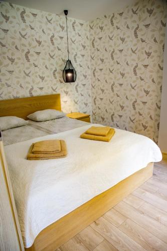 a bedroom with a large bed with white sheets at Apartamenty Przy Świerku in Wisła