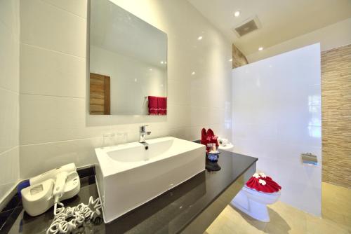 a white bathroom with a sink and a mirror at Crystal Bay Yacht Club Beach Resort in Lamai