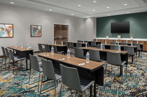 a conference room with tables and chairs and a screen at Hampton Inn Orlando Southeast Nona in Orlando