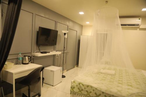 a bedroom with a bed with a veil on it at Hotel Reemz in Chiplun