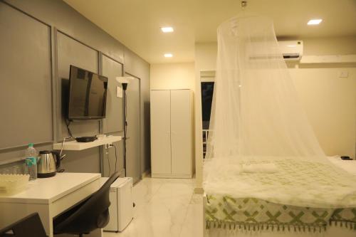 a bedroom with a bed with a veil on it at Hotel Reemz in Chiplun