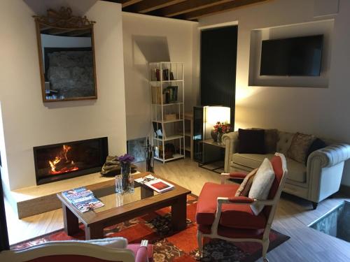 a living room with a couch and a fireplace at Hotel Gredos María Justina in Navacepeda de Tormes