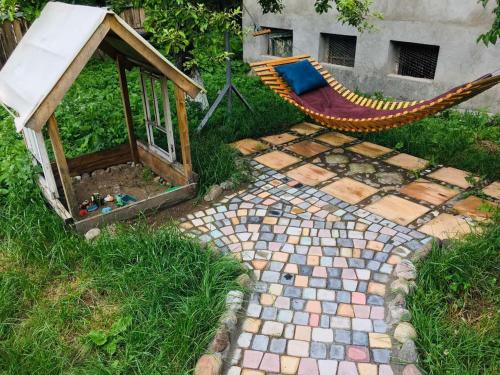 a garden with a hammock and a bird house at Motkor Guest House in Martsʼ