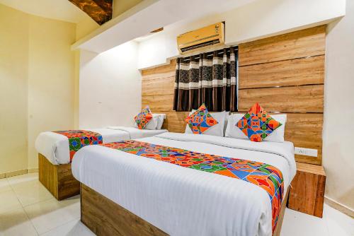 a bedroom with two beds in a room at FabExpress Amber Corp Inn - Nr NESCO Exhibition Center in Mumbai