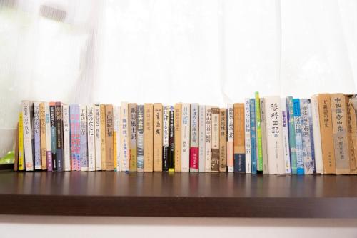 a row of books sitting on a shelf at 一組貸切宿 岡村 弐番館 limited to 1group per day 一棟まるまる貸切 in Suwa