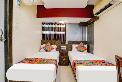a room with two beds in a room at FabExpress Amber Corp Inn - Nr NESCO Exhibition Center in Mumbai
