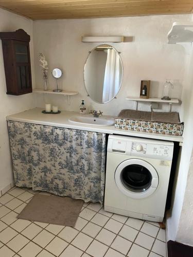 a bathroom with a sink and a washing machine at Roligt Landhus in Vrå