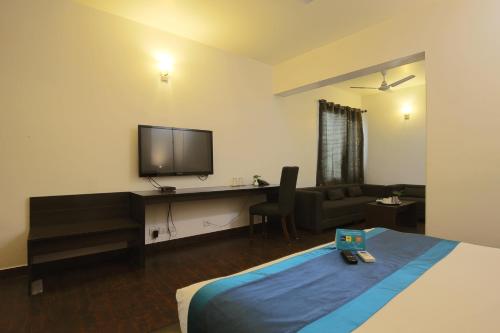 a hotel room with a bed and a desk with a television at The Saneer Jaipur in Jaipur
