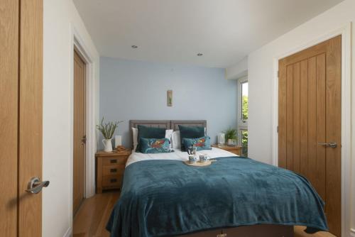 a bedroom with a large bed with a blue blanket at 5 Sandy Lane Apartments, Carbis Bay in Carbis Bay