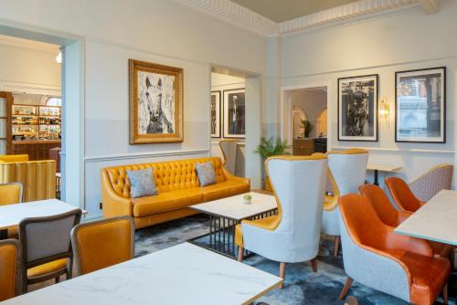 a restaurant with a couch and tables and chairs at The Queen at Chester Hotel, BW Premier Collection in Chester