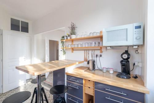 a kitchen with a wooden counter and blue cabinets at T3-Isabelle et Christian in Mâcon