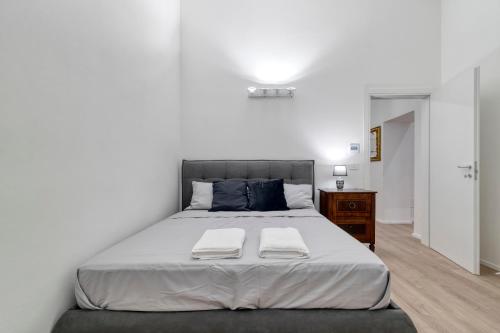 ボローニャにあるCarbonara Palace 1 - Luxury Comfort under Medieval Towersの大きなベッドとタオル2枚のある寝室