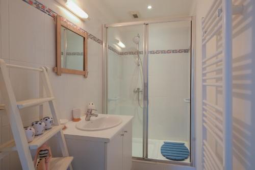 une salle de bain blanche avec une douche et un lavabo dans l'établissement Horizon d'Azur - Appt avec vue sur la fôret, à Saint-Nazaire