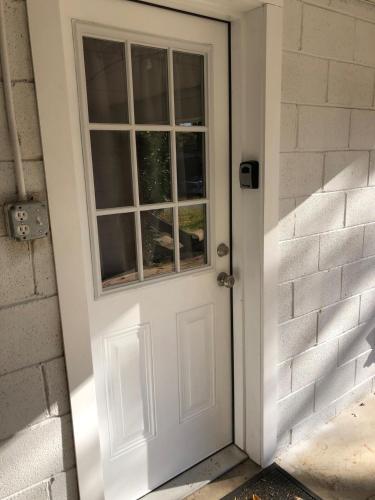 a white door with a window on a brick wall at Heart Of Hickory Home #2 Open Layout Studio Apt in Hickory