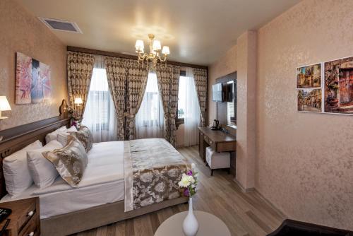 a bedroom with a large bed and a desk at Perapolis Hotel in Istanbul