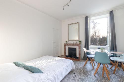 a bedroom with a bed and a table and a fireplace at T3-Isabelle et Christian in Mâcon