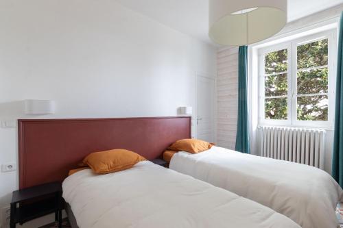 two beds in a room with a window at T3-Isabelle et Christian in Mâcon