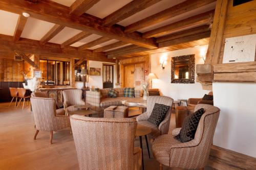 a living room with couches and tables and chairs at La Ferme du Golf in Megève